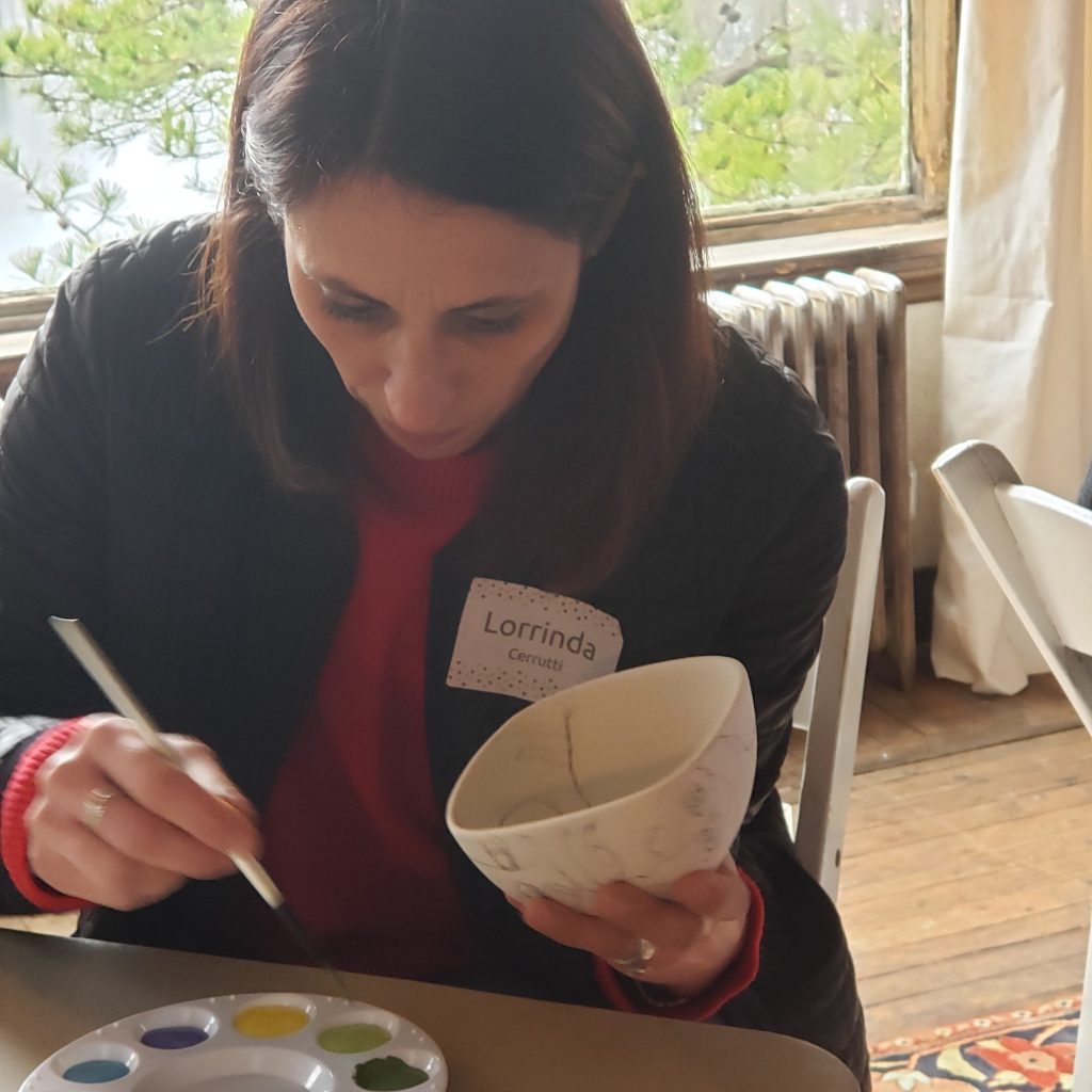 Lorrinda Cerrutti painting a ceramic bowl at the Manship residence for the Open Door's Empty Bowl